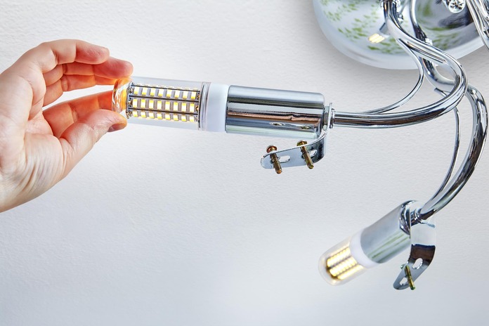 Homeowner installing a ceiling light fixture following step-by-step instructions